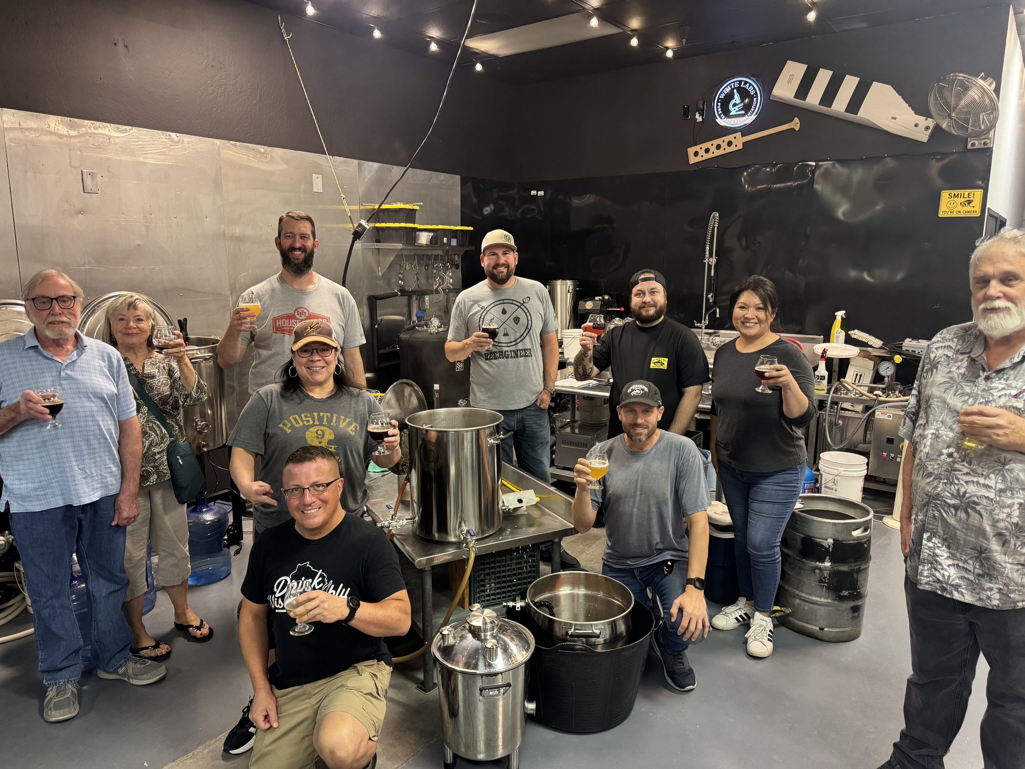 A group of homebrewers toasting glasses inside the Hopsology brew room