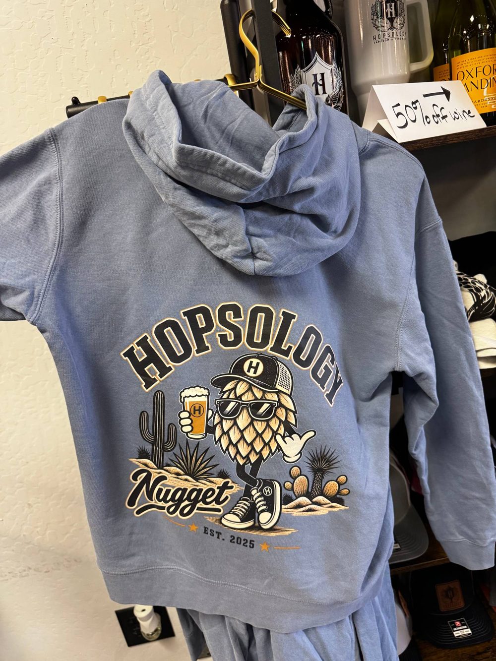 Hopsology Nugget hoodie, light blue with a desert-themed hop mascot graphic on the back